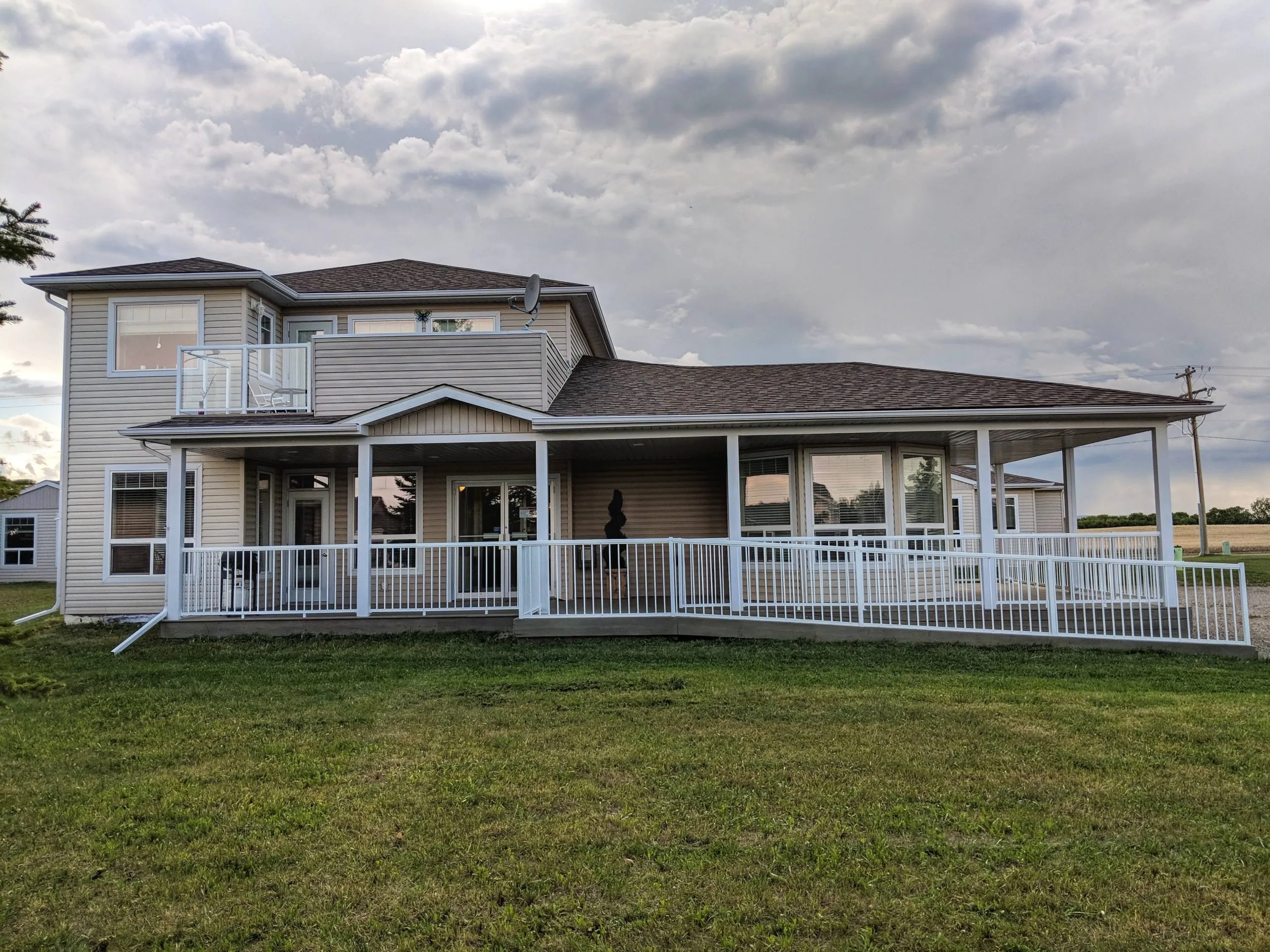 Freedom Living building and wraparound veranda seen across the lawn in summer